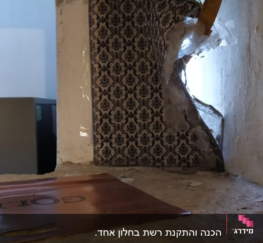 קיר עם טפט קרוע וכלי עבודה